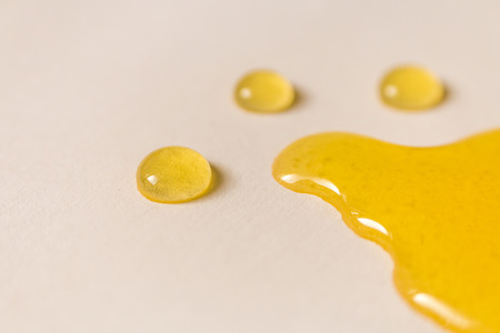 melting honey and drops on white backgroundの写真素材