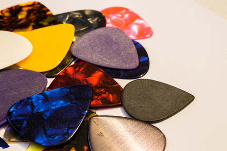 Multi-colored guitar pick on white backgroundの写真素材