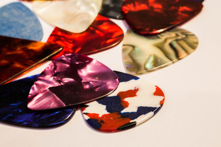 Multi-colored guitar pick on white backgroundの写真素材