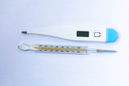 Mercury and digital thermometer on white background