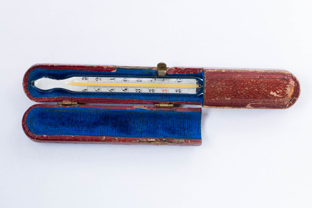 mercury thermometer in an old battered box on white background