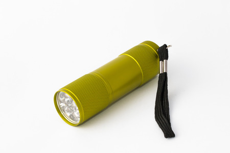 Yellow-green led aluminum flashlight on a white backgroundの写真素材