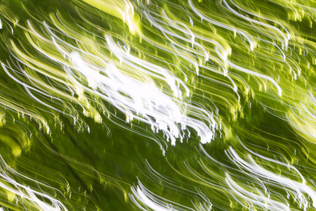 Abstract light patterns on blurred green forest backgroundの写真素材