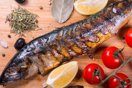 Mackerel baked with lemon, cherry tomatoes, olive and spicesの写真素材