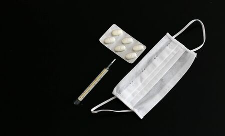 Pills, thermometer and medical mask on black backgroundの写真素材