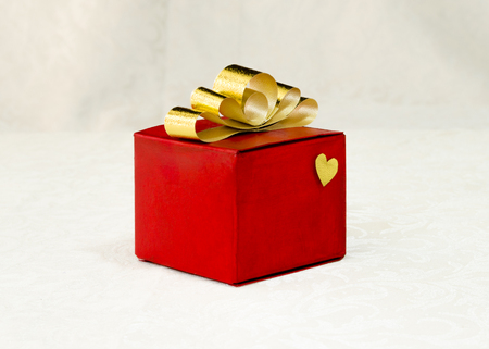 golden ribbon bow on a gift red boxの写真素材