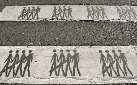 Detail of Zebra traffic walk way with drawings of pedestriansの写真素材