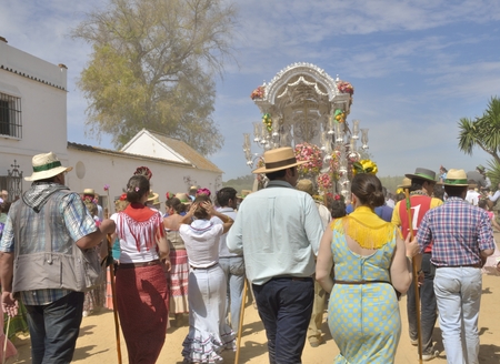 Pilgrims behind the badge of the brotherhood of Triana on his pilgrimage to the village of El Rocio,...