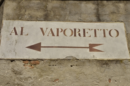 Directional sign to Vaporetto on old Venetian building, Italyのeditorial素材