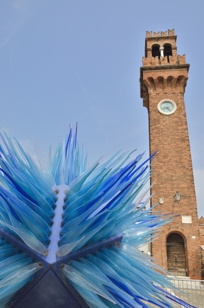 Clock tower and a blue murano glass sculpture  in Murano, Venice, Italy.のeditorial素材