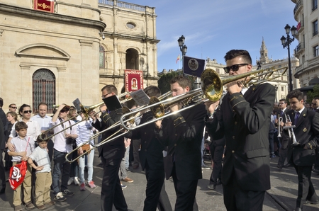 Musical accompaniment of a trumpet band behind the image of  a religous procession  in the Holy week...
