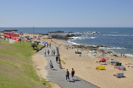 People walking and having sun  in the beach of Foz district in Porto, Portugal.のeditorial素材
