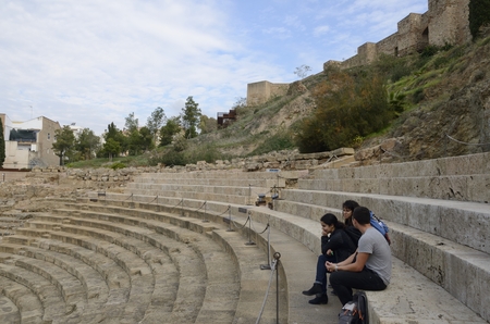 People at the seats of the Roman theater, at the foot of the Alcazaba fortress, in Malaga, Spain.のeditorial素材