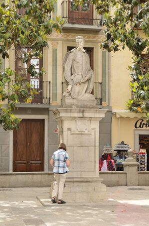 Woman in front of memorial monument to  Alonso Cano, Grenadian artist in plaza located in the old town of Granada, Andalusia, Spain.のeditorial素材