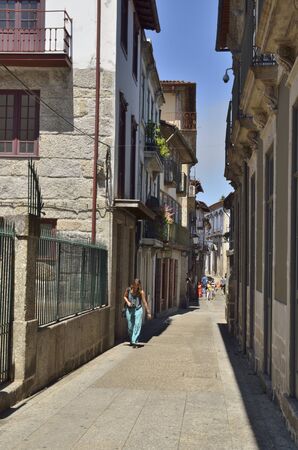 Guimaraes, Portugal - August 9, 2115:  People at narrow street of the old town of Guimaraes,...