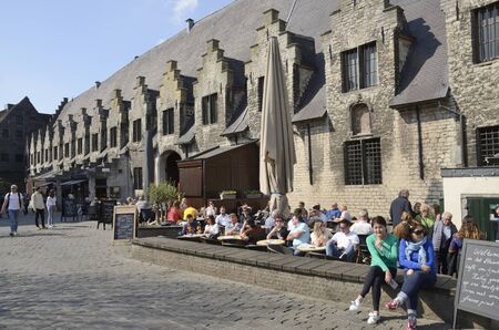Ghent, Belgium - March 31, 2019: People at outdoor bar next to historic building in Ghent,  the capital of the East Flanders province in Belgium.のeditorial素材