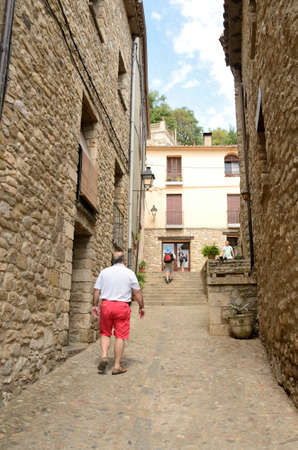 Besalu, Spain - July 26, 2017: Men by narrow alley in Besalu, a medieval town of Girona, Catalonia, Spain.のeditorial素材