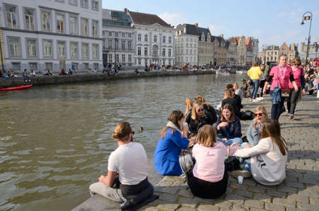 Ghent, Belgium - March 31, 2019: People at the cobbled footpath along the canal in the Old Town of Ghent, the capital of the East Flanders province in Belgium.のeditorial素材