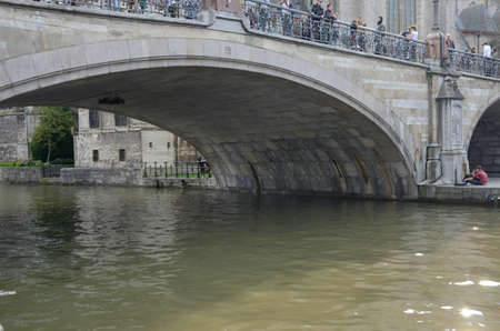 Ghent, Belgium - March 31, 2019: People on the bridge over the canal in the Old Town of Ghent, the capital of the East Flanders province in Belgium.のeditorial素材
