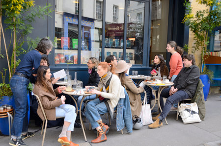 Paris, France - March 17, 2023: People at cafe terrace of bookshop located in the Latin Quarter in Paris, France.のeditorial素材