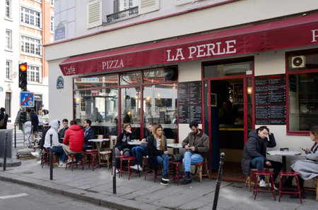 Paris, France - March 18, 2023: People at outdoor cafe in street located in The Marais quartier in Paris, France.のeditorial素材