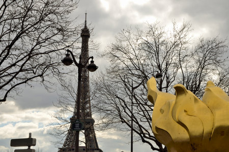 Paris, France - March 19, 2023: The Flame of Liberty, a gold leaf covered replica of the flame from the Statue of Liberty and the Eiffel Tower at Diana Plaza in Paris, France.のeditorial素材