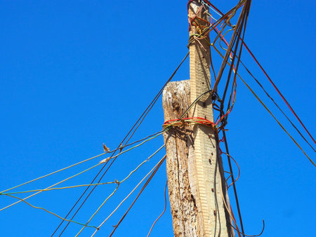 Light poles made from old wood with wire of informal settlements, huts made of metal in the Township or Cape Flats of Stellenbosch, Cape Town, South Africa, with blue sky backgroundの写真素材