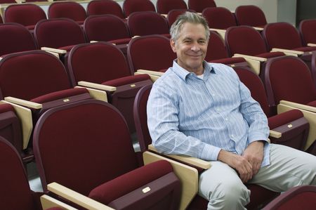 Man sitting in auditorium chair, portrait, elevated viewの写真素材