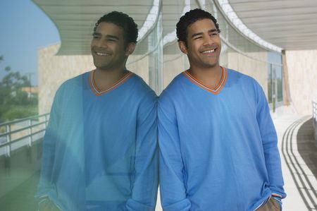 Man leaning on window, outdoors, portraitの写真素材