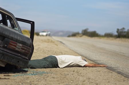 Victim of car accident lying on roadsideの写真素材