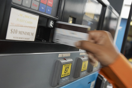 Person paying with credit card at gas pump, motion blurの写真素材