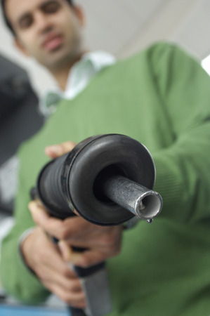 Man holding gas pump, focus on foreground