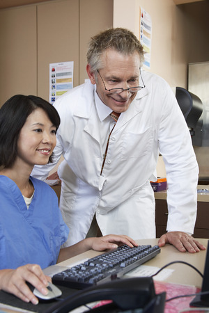 Nurse and doctor working on computerの写真素材