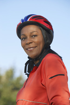 Senior woman wearing cycling helmet, outdoors, portraitの写真素材
