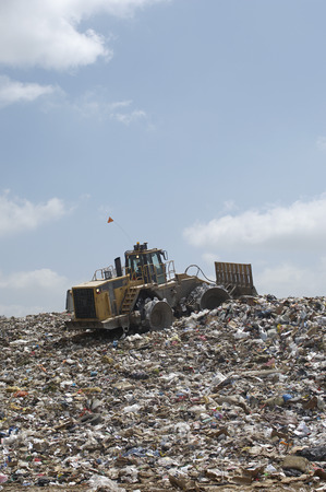 Digger working at landfill site