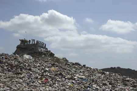 Digger working at landfill site