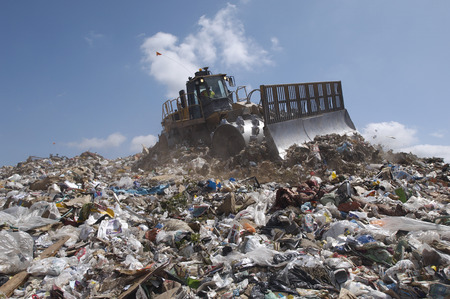 Digger working at landfill site