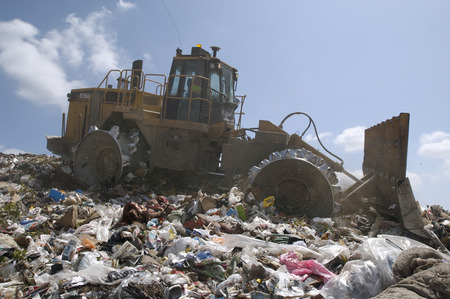 Digger working at landfill site