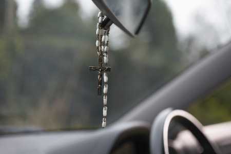 Rosary beads hanging in carの写真素材