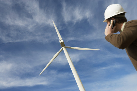 Engineer using mobile phone at wind farm