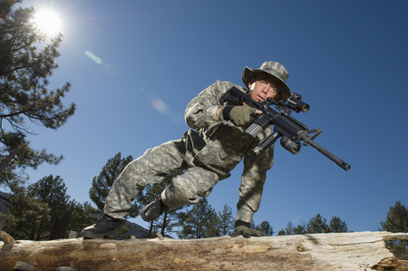 Soldier jumping over logの写真素材