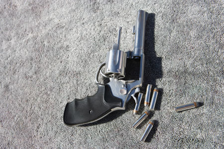 Hand gun and bullets on carpet