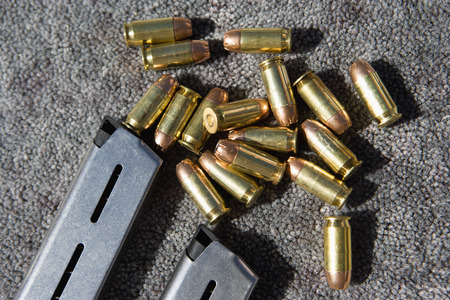 Gun magazine and bullets on carpet, close-up