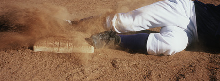 Baseball player lying in dirt, low sectionの写真素材