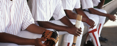 Baseball players sitting in dugoutの写真素材