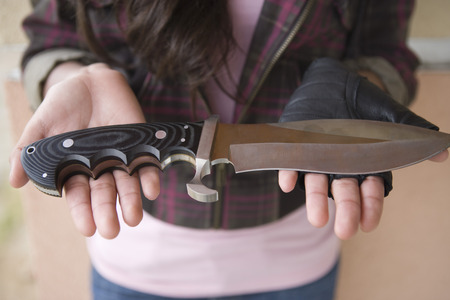 Young woman holding knife on her palms