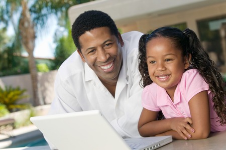 Father and Daughter Using Laptopの写真素材
