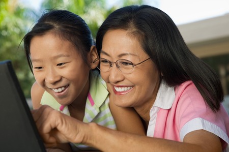Mother and Daughter Using Laptop Togetherの写真素材