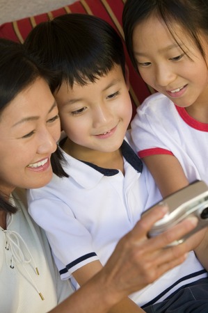 Mother and Children Looking at Digital Cameraの写真素材
