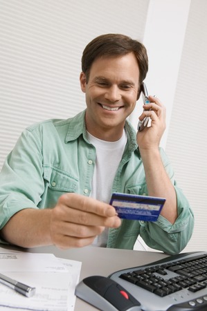 Man Using Credit Card to Order Over Phoneの写真素材